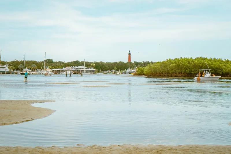 A calm Florida inlet with boats and a lighthouse